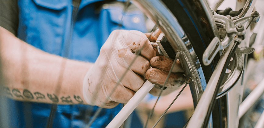 Mann repariert ein Fahrrad in der Radstation Hannover