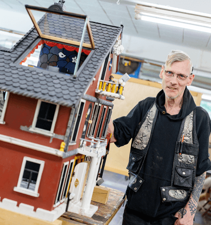 Bewohner präsentiert sein selbstgebautes Puppenhaus